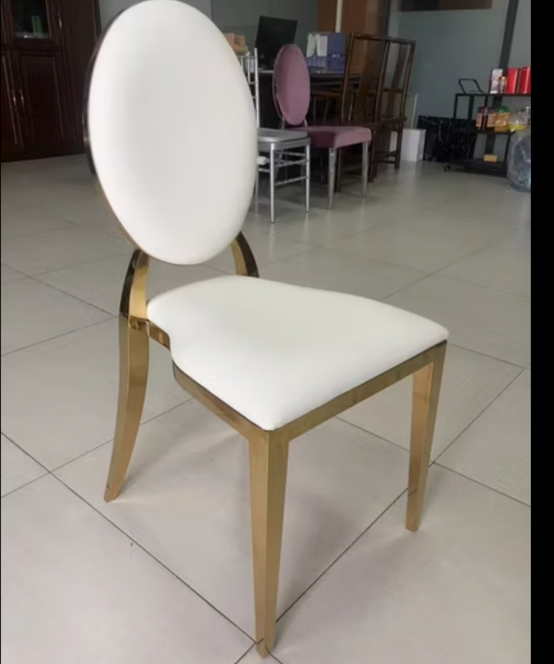 Gold Comfort chair with cushioned oval back, gold frame, white upholstery
